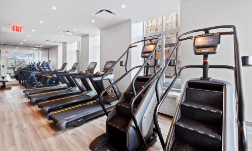 fitness center with equipment and spacious areas on wood-style flooring