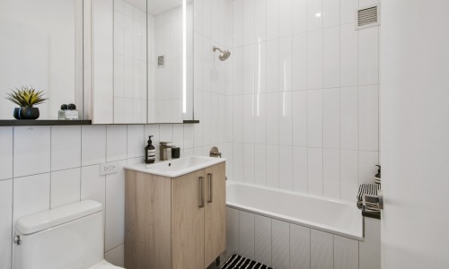 Bright bathrooms with brushed nickel fixtures that provide ample storage with custom, oversized recessed mirrored medicine cabinets in select apartments. Cover Image