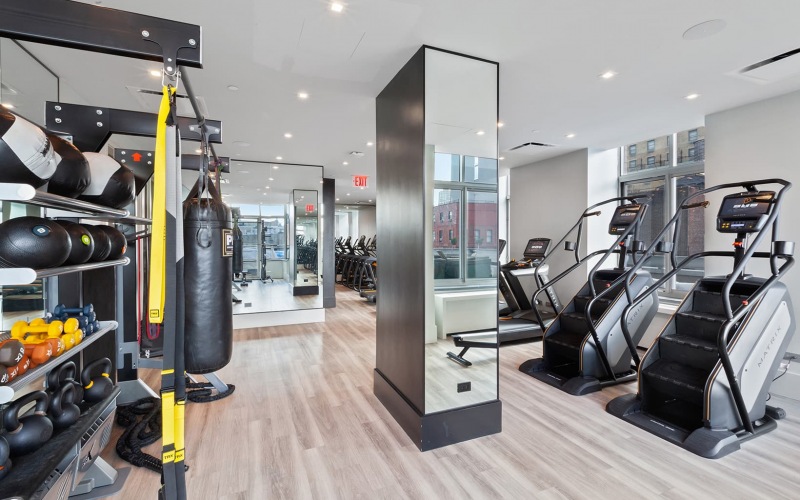 fitness center with equipment and spacious areas on wood-style flooring