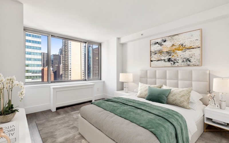bedroom with ample space for moving around the bed and views of downtown